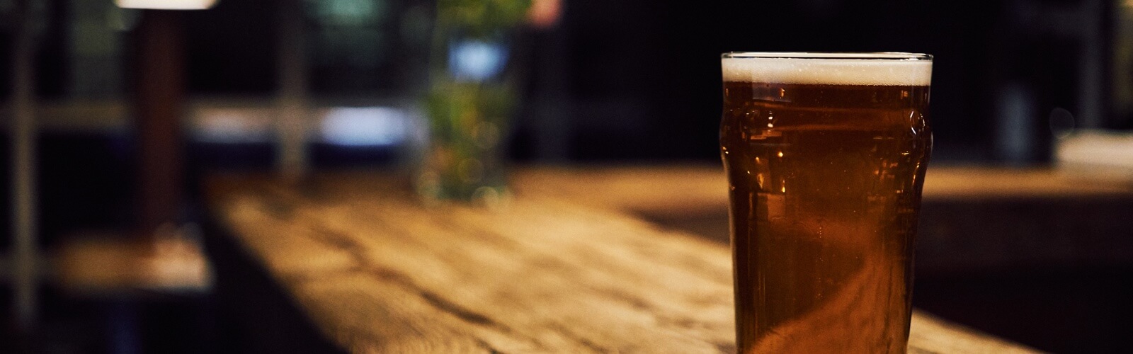 pint of beer on wooden bar top
