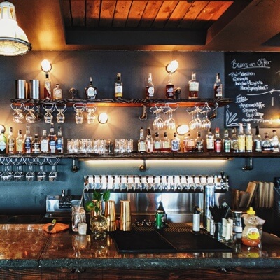 back of bar with bottles of liquor on shelves